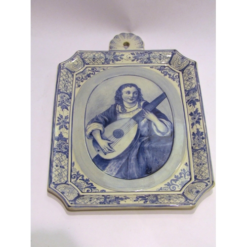 4468 - A Delft blue and white wall hanging plaque depicting flute player, 31cm x 21cm