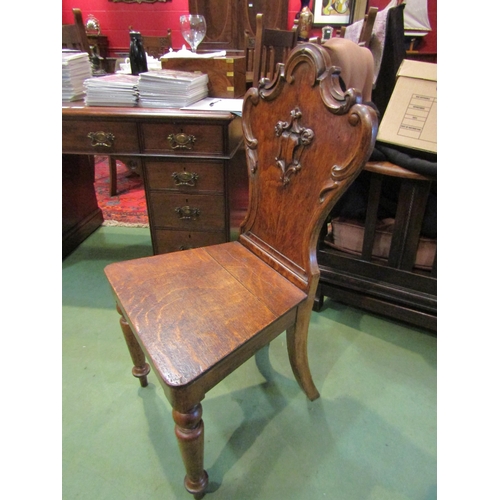 4200 - A mahogany carved shield back hall chair with turned fore legs