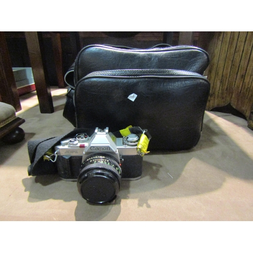 4240 - A Canon AV-1 camera with two lenses, multiplier and speed light, all in leather case