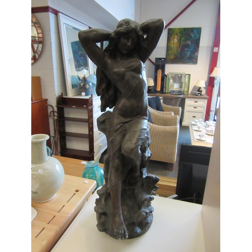 1120 - A bronze spelter floor-standing sculpture of semi-clad maiden seated upon rocks, 60cm high