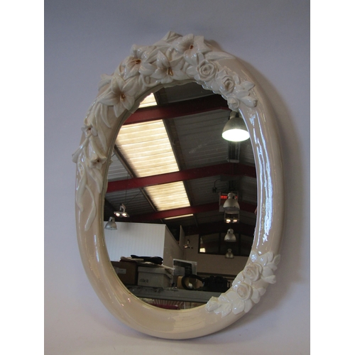 1382 - A ceramic oval wall mirror with floral design, 63cm tall