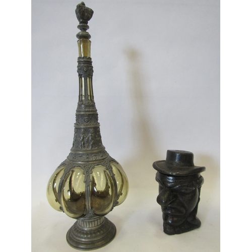 1383 - A spelter and amber glass bottle with stopper and a cast iron head form tobacco jar