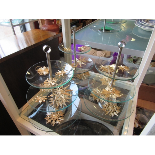 1210 - Three glass three tier cake stands with a selection of straw tree hangings