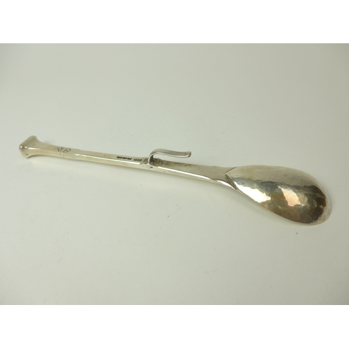 7023 - A Guild of Handicrafts hammered spoon with hanger to back, 18.6cm long, London 1964, 75g