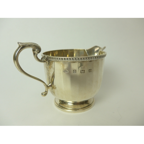 7148 - An Adie Brothers Ltd silver cream jug of Deco form, 7.5cm tall, Birmingham 1927, 129g