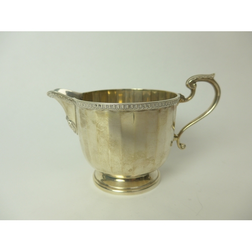 7148 - An Adie Brothers Ltd silver cream jug of Deco form, 7.5cm tall, Birmingham 1927, 129g