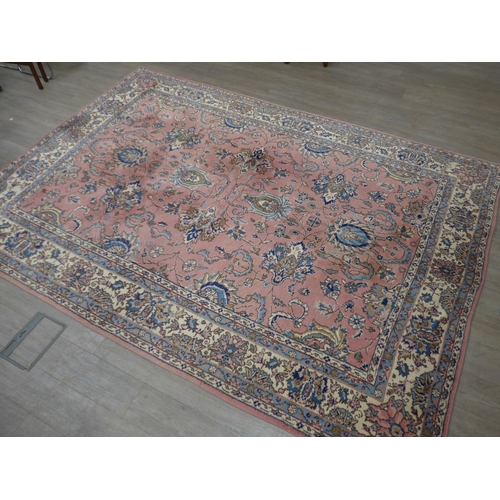 7631 - A pink ground carpet with substantial wear to one side, 247cm x 352cm