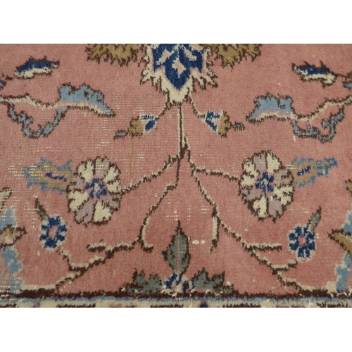 7631 - A pink ground carpet with substantial wear to one side, 247cm x 352cm