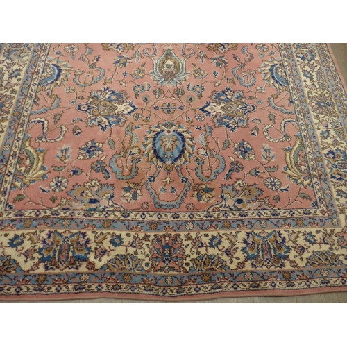 7631 - A pink ground carpet with substantial wear to one side, 247cm x 352cm