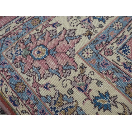 7631 - A pink ground carpet with substantial wear to one side, 247cm x 352cm