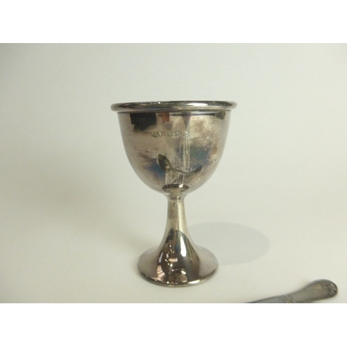 7110 - A cased silver Atkin brothers egg cup and spoon set. Sheffield 1946 & 1945, 69g