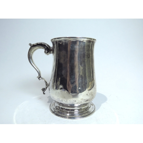 7085 - A George III James Waters baluster tankard with scroll handle, circular spread foot, dents present t... 