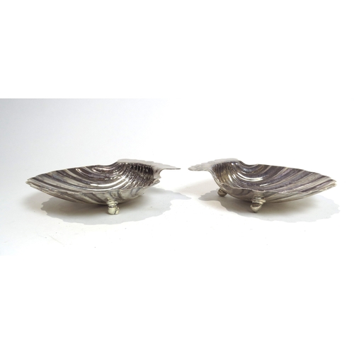 7058 - A pair of George II Samuel Herbert silver scallop-form butter dishes raised on conch shell feet, wit... 