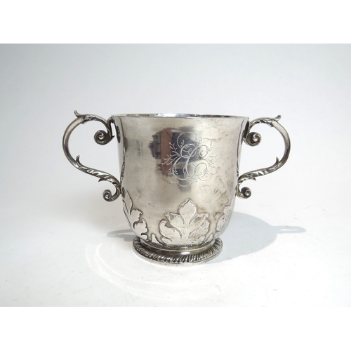 7065 - An early 18th Century silver twin handled cup with acanthus detailing.  The body decorated with Armo... 