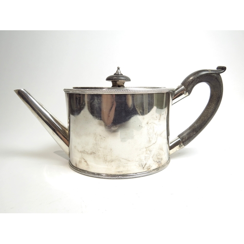 7078 - A George III silver oval-form teapot with beaded borders, bird crest detail to body, treen handle an... 