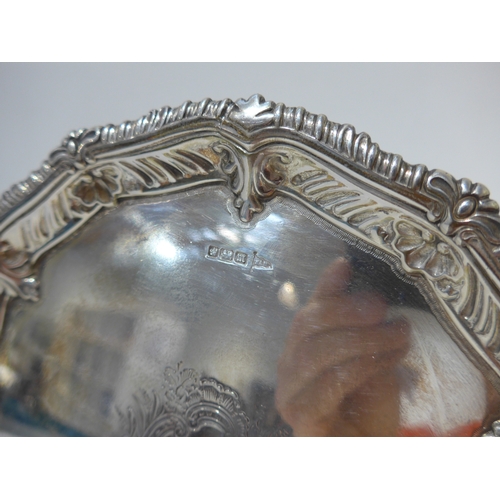 7014 - A Walker & Hall silver waiter with wrythen and shell pattern edge, central cartouche raised on ball ... 