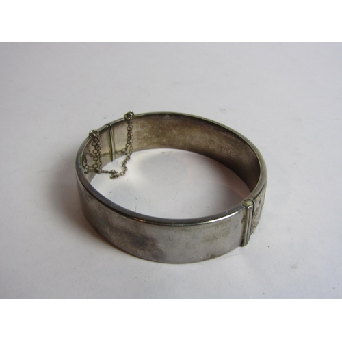 4409 - A silver bangle with engraved floral design