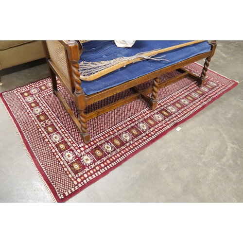 2487 - A white and red hand woven wool rug 120 x 86cm