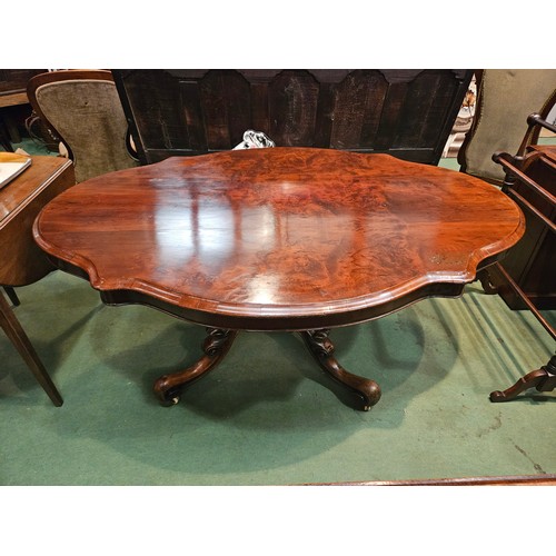 4223 - Circa 1850 a walnut tilt-top table, the serpentine sided top over a melon fluted and turned column o... 