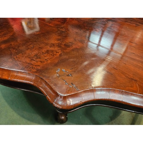 4223 - Circa 1850 a walnut tilt-top table, the serpentine sided top over a melon fluted and turned column o... 