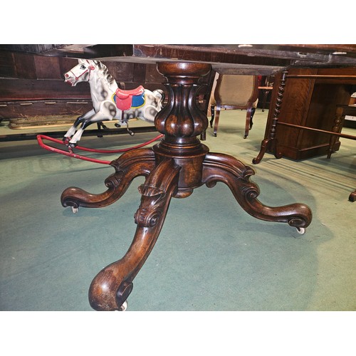 4223 - Circa 1850 a walnut tilt-top table, the serpentine sided top over a melon fluted and turned column o... 