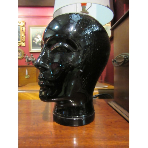 4011 - A black glazed mannequin head of woman, 24cm tall