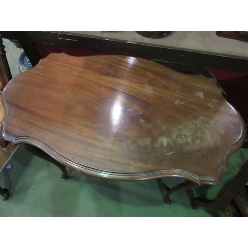 4018 - An Art Nouveau walnut two tier lamp table in the manner of 'Liberty & Co' the shaped top over unusua... 