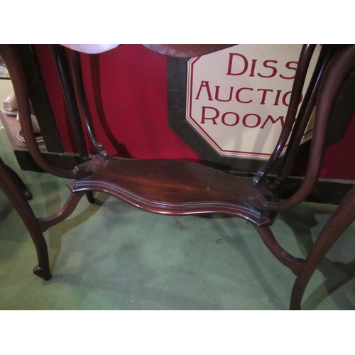 4018 - A art nouveau walnut two tier lamp table in the manner of 'Liberty & Co' the shaped top over unusual... 