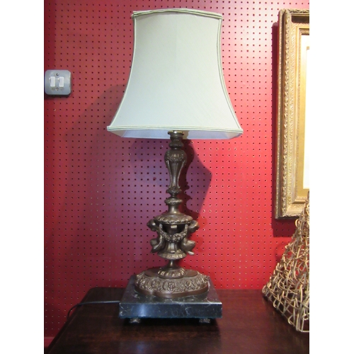 4029 - A brass bronze effect figural table lamp with fern and mask detail on marble base, with pale green s... 