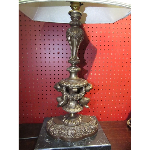 4029 - A brass bronze effect figural table lamp with fern and mask detail on marble base, with pale green s... 