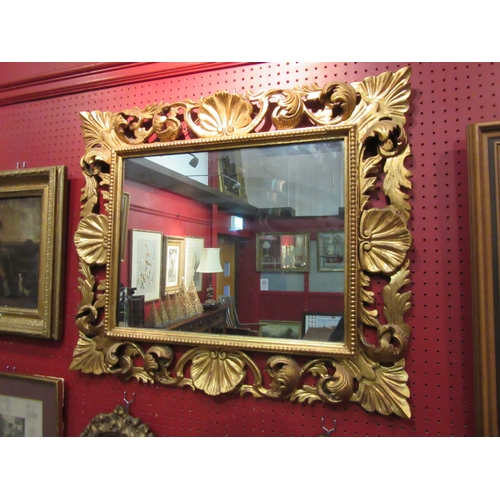 4051 - An ornate gilded frame wall mirror of rectangular form, 60cm x 70cm