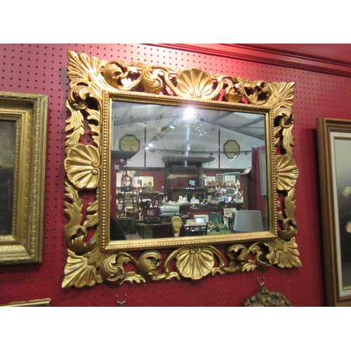 4051 - An ornate gilded frame wall mirror of rectangular form, 60cm x 70cm