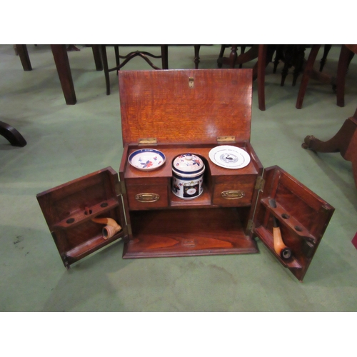 4076 - An early 20th Century oak tobacco cabinet with ivy leaf carved detail, associated ceramics and drawe... 