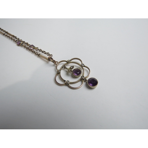 7027 - An Edwardian amethyst and seed pearl pendant, stamped 9ct hung on a gold chain with amethyst spacers... 