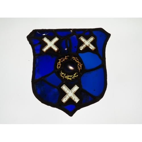 7626 - A shield shaped leaded glass panel, cobalt blue, central roundel with X's top and bottom, some damag... 