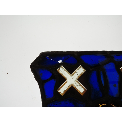 7626 - A shield shaped leaded glass panel, cobalt blue, central roundel with X's top and bottom, some damag... 