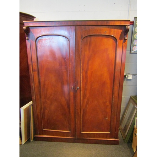 1069 - An Edwardian mahogany two door wardrobe with scrolled acanthus leaf detail, linen trays and three in... 