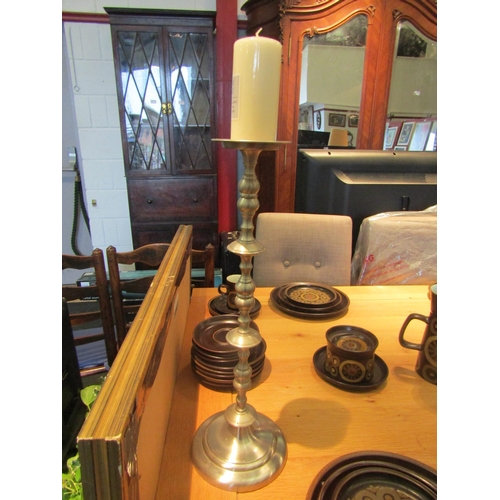 1079 - A chrome candlestick, 50cm tall, and a pillar candle