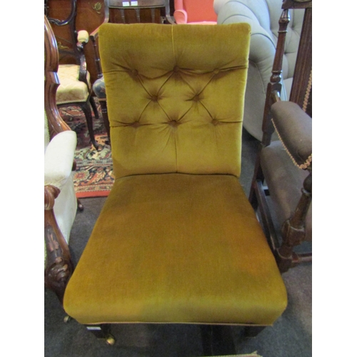 1184 - A Victorian button back open armchair with tapering legs to casters