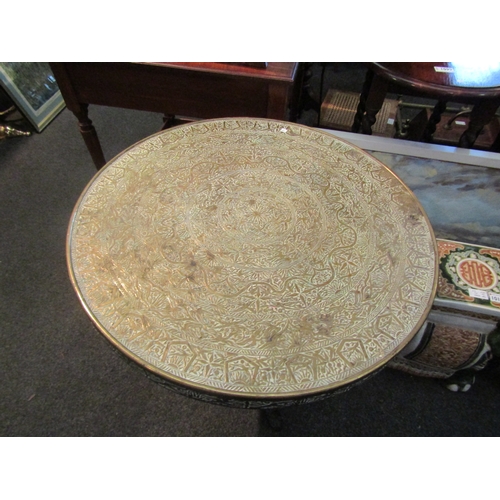 1102 - A cast iron base pedestal table with Indian brass top, 63cm tall x 59cm diameter