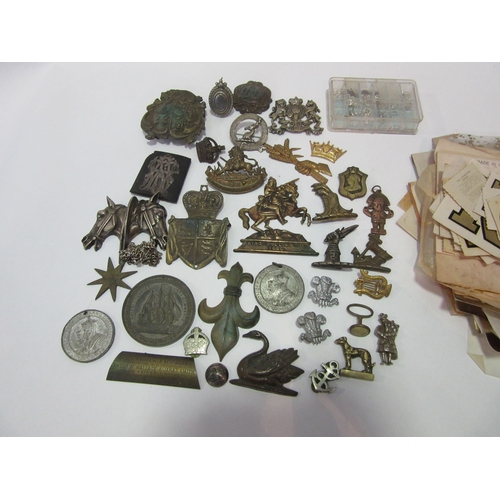 1398 - A box of miscellaneous metalwares to include horse heads, fleur-de-lis, crests etc.