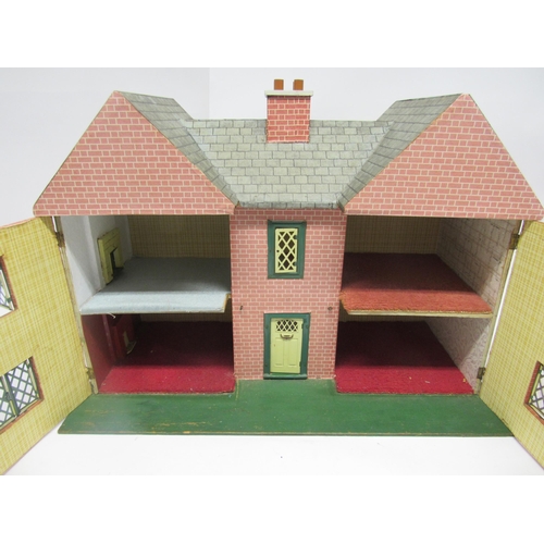 9225 - A mid 20th Century front opening two storey dolls house with tinplate front door and windows, attrib... 