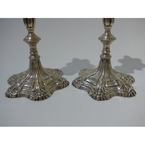 8002 - A pair of George III Ebeneezer Coker solid silver candlesticks with shell and rope detail, shaped ci... 