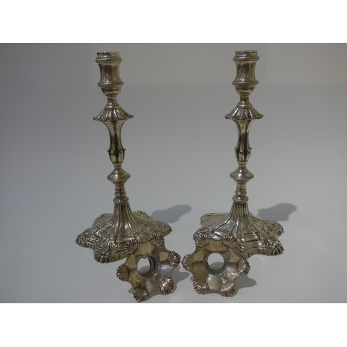 8002 - A pair of George III Ebeneezer Coker solid silver candlesticks with shell and rope detail, shaped ci... 