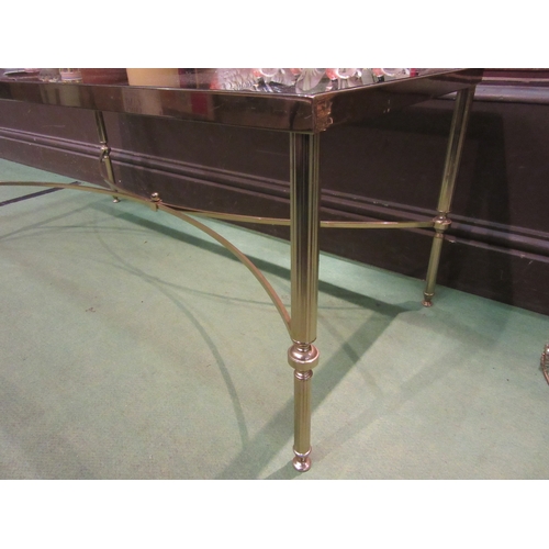 4309 - A brass and smoky glass rectangular occasional table on tapering legs united by an 'X' framed stretc... 