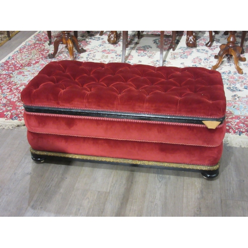 4146 - A Victorian upholstered and ebonised box seat ottoman, the hinged buttoned seat over bun feet and wh... 