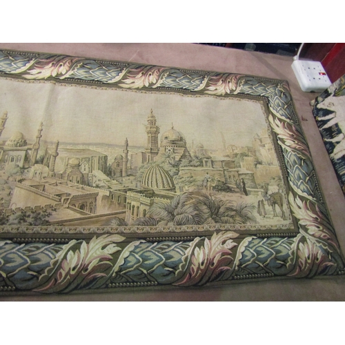 4010 - A tapestry wall hanging of a Middle Eastern town with floral border, 69cm x 160cm