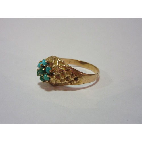 1376 - A gold ring with turquoise cabochon daisy to centre, textured shoulders, size M/N, 3.6g