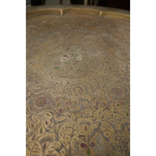 2010 - An Eastern carved hardwood table with brass top, the base carved from one piece