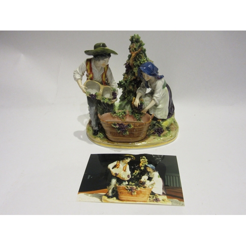 4340 - A Capodimonte figural group of boy and girl pressing grapes in harvest barrel, 18cm tall